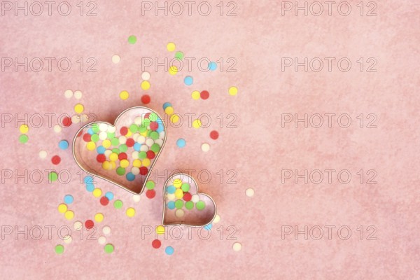 Two heart-shaped baking pans and sugar confetti