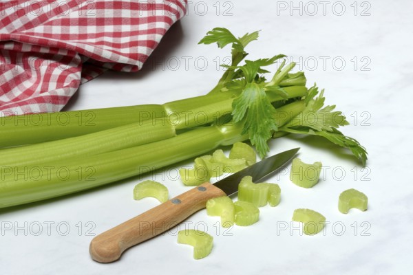 Celery stalks, celery pieces and knife
