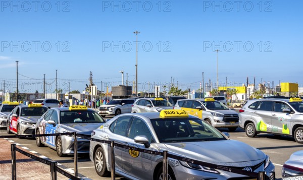 Taxi and hop on hop off buses are waiting for tourists in the cruise terminal parking lot, Abu Dhabi, UAE, United Arab Emirates