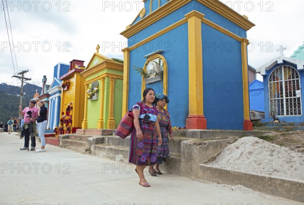 Mayan woman wearing traditional clothing at colorful graves at the cemetery in Chichicastenango, Highlands, El Quiché Department, Guatemala