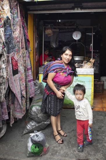 Mayan woman with toddler in traditional clothes at the market in Chichicastenango, Highlands, El Quiché Department, Guatemala