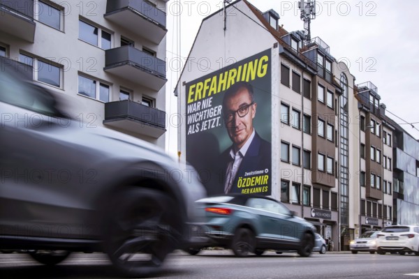 Mega poster on a house pediment. Cem Özdemir, leading candidate of the Green Party. 2026 state election in Baden-Württemberg. Election advertising in the city center of Stuttgart. Stuttgart, Baden-Württemberg, Germany