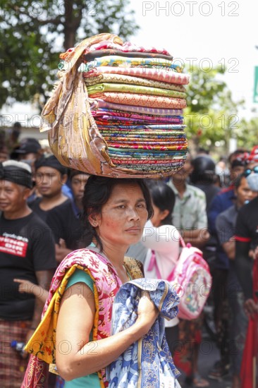 Balinesin sells sarongs during a ceremony, Bali, Indonesia