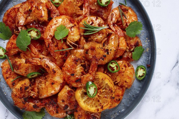 Grilled shrimp, unpeeled, headless, with spices, on a marble table, homemade, no people