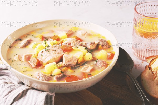 A bowl of soup on a light background, Finnish fish soup, lohikeito soup, creamy fish soup