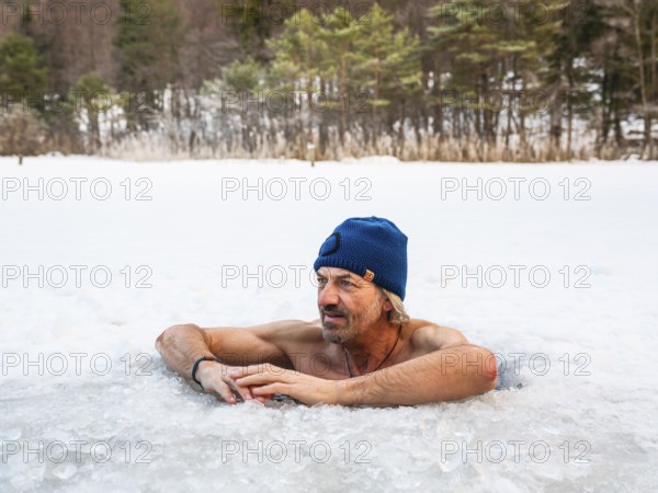 Man with cap, 55, ice bathing in an ice hole, Thumsee, Bad Reichenhall, Berchtesgadener Land, Upper Bavaria, Bavaria, Germany