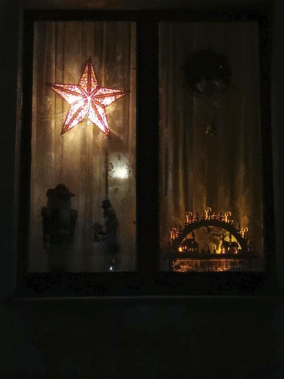 A dark window with a glowing star and interior shadows, Christmas lights, Thuringian Forest, Rennsteig