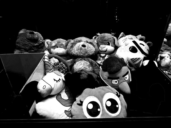 Collection of various stuffed animals in a dark environment, black and white photo of a toy vending machine, Claw machine, Batumi, Georgia