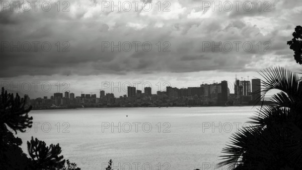 View across the sea to a distant skyline under a cloudy sky, Batumi, Georgia