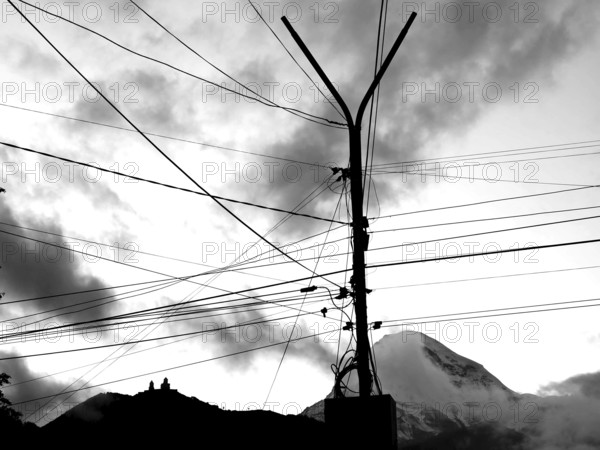 Power lines against a cloudy sky with a mountain in the background, Kazbegi, Stepantsminda, Georgia