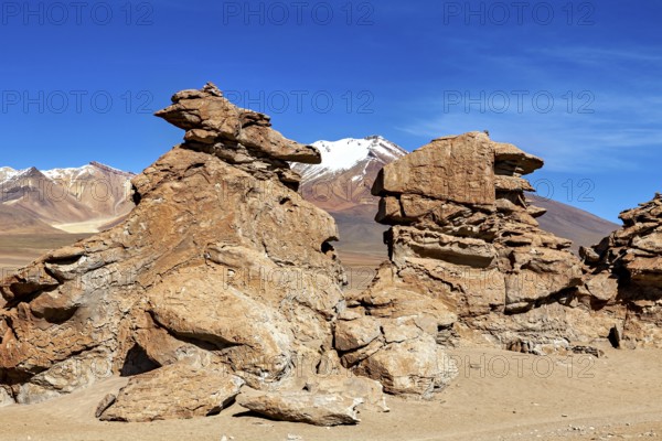 Majestic rock formations in a vast, barren desert landscape under blue skies, The Altiplano landscape in Bolivia