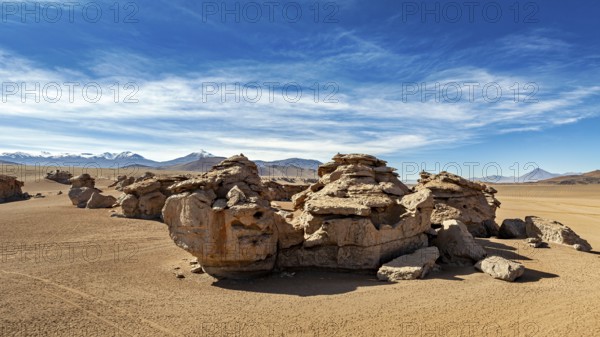 Impressive rock formations in a sandy desert landscape under clear skies, The landscape of the Altiplano in Bolivia