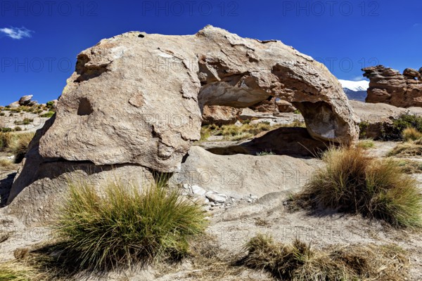Natural stone arch in a dry desert landscape under bright blue sky, The landscape of the Altiplano in Bolivia