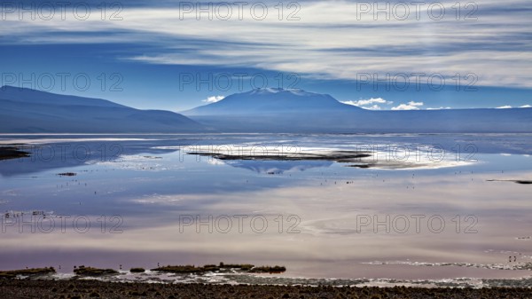 Dramatic cloud formations over a reflecting lake and distant mountain ranges, The Laguna Colorada in the Altiplano in Bolivia