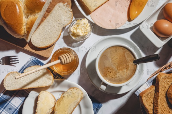 Breakfast, stollen with butter and honey, surrounded by cheese, ham, coffee, peppers and eggs
