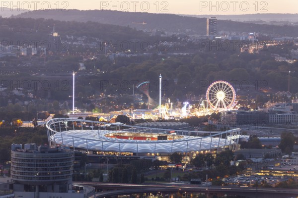 29 Sep 2018 at dusk, Volksfest lights seen from Rotenberg chapel with stadium foreground and Pragsattel background. Stuttgart, Baden-Wurttemberg, Germany