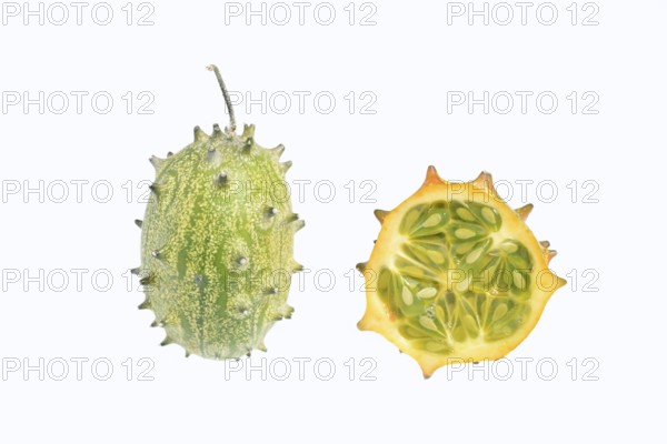 Horned cucumber, kiwano or horned melon (Cucumis metuliferus), whole and sliced fruit on a white background, native to Africa