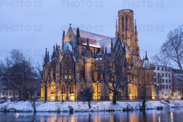 March 18, 2018, winter dusk with snow, illuminated lake and Gothic church Johanneskirche, calm reflections, Feuersee, Stuttgart, Baden-Württemberg, Germany