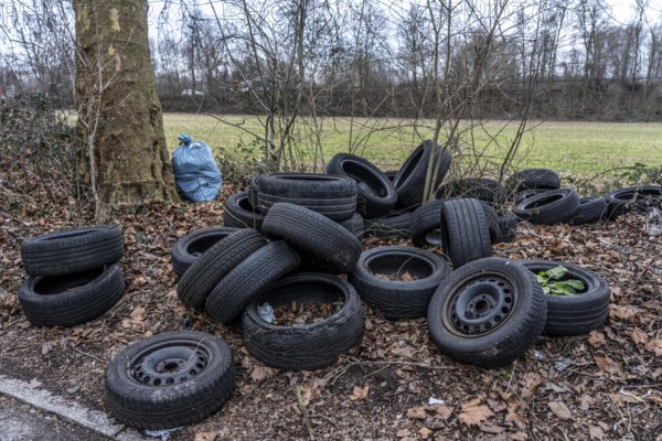 Illegally disposed of car tires and other trash, on a side street in Duisburg-Kaiserberg, North Rhine-Westphalia, Germany