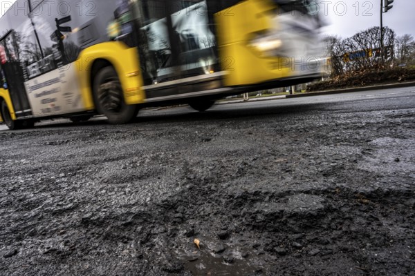 Large potholes at the confluence of Kruppstraße with Friedrichstraße, B224, heavy vehicle traffic, cars and trucks, as well as winter weather conditions have severely added to the road surface, Essen, North Rhine-Westphalia, Germany
