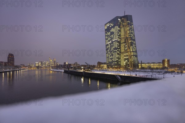 Snow lies along the banks of the Main from the European Central Bank (ECB) to the Frankfurt banking skyline, Osthafen, Frankfurt am Main, Hesse, Germany