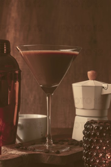 Espresso martini cocktail, alcoholic drink, shaker and geyser coffee maker, on a wooden background