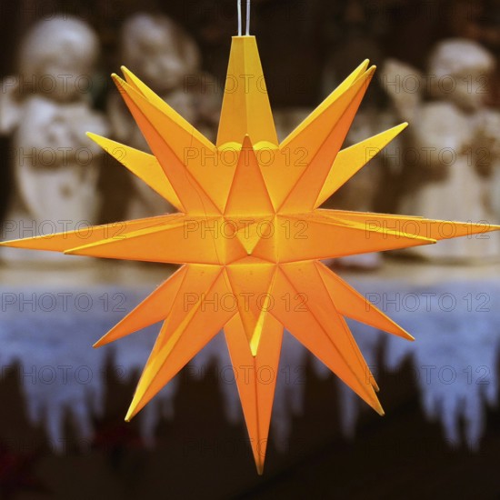 Glowing Christmas star in front of angel figures at the Christmas market, detail, Paderborn, Ostwestfalen-Lippe, North Rhine-Westphalia, Germany
