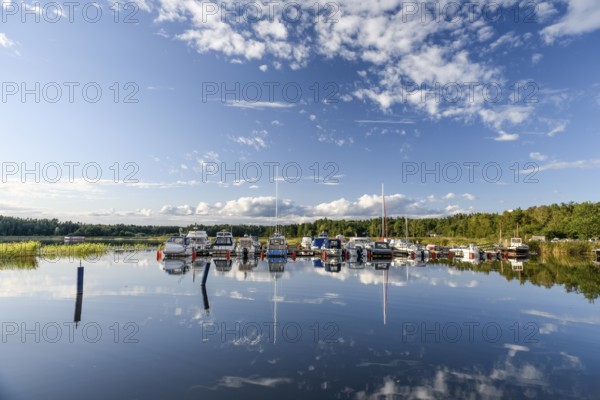 Several boats are moored in the quiet pleasure boat harbor of Ekenäs, water reflects the sky, Ekenäs, Värmlandsnäs peninsula, Värmlands län, Sweden