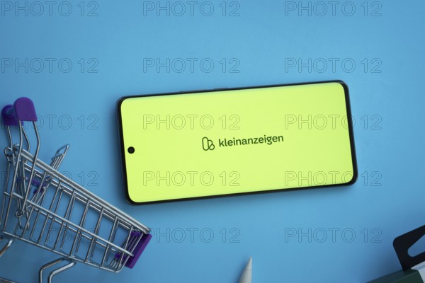 Dhaka, Bangladesh- 03 July 2025: Smartphone displaying Kleinanzeigen logo with shopping cart on a blue background