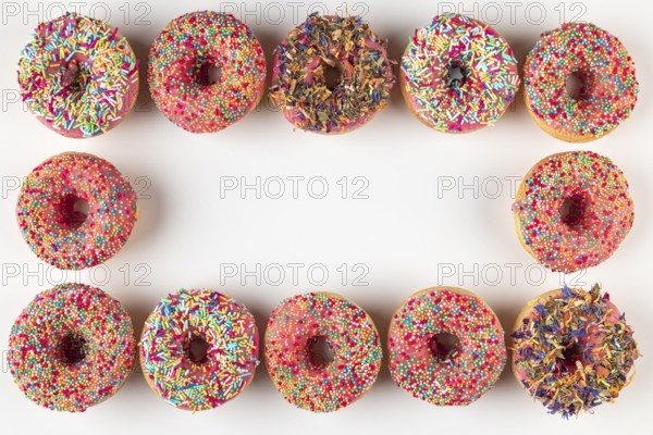 Donut frame with colorful sprinkles on white background
