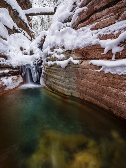Taugl or Tauglbach flows through the snow-covered and icy red gorge, also Marmorklamm, Bad Vigaun, Tennengau, Salzburg, Austria