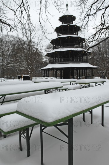 Winter in the English Garden, snow-covered beer garden tables and benches, Chinese Tower, Munich, Bavaria, Germany