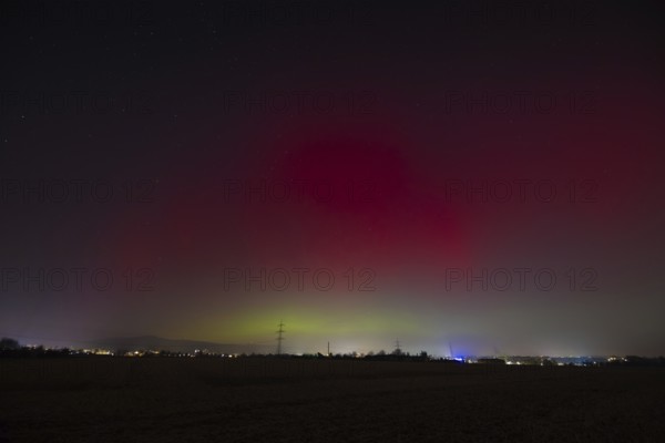 Northern lights (aurora borealis) glow red and green in the evening sky over Germany, Frankfurt am Main, Hesse, Germany