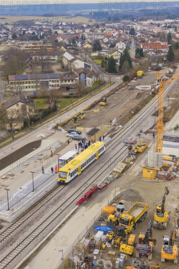 Aerial view of a construction site with a yellow train on the tracks and construction cranes, acceptance of the Hermann Hesse Railway, Calw, Black Forest, Germany