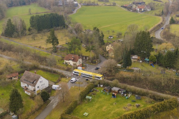 Rural scene with yellow train on rails, surrounded by trees and houses in the countryside, acceptance of the Hermann Hesse Railway, Calw, Black Forest, Germany