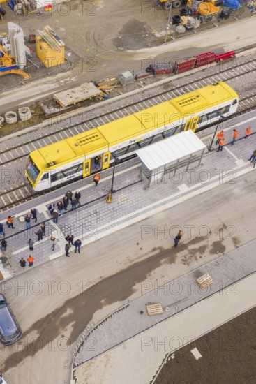 Bird's eye view of yellow train on a busy platform, taking off the Hermann Hesse Railway, Calw, Black Forest, Germany