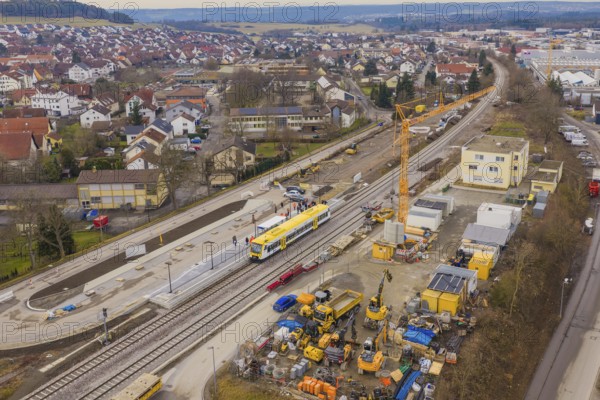 Construction site in urban area with yellow train and crane, surrounded by residential buildings, acceptance of the Hermann Hesse Railway, Calw, Black Forest, Germany