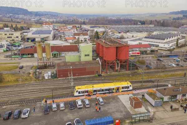 Aerial view of an industrial area with yellow train and large building structures, acceptance of the Hermann Hesse Railway, Weil der Stadt, Black Forest, Germany