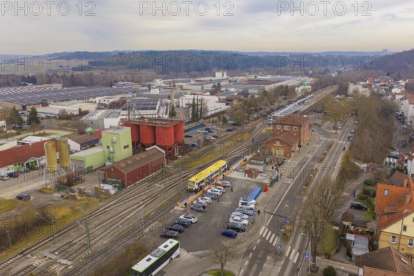 Aerial view of a train station with a yellow train, industrial buildings and parked cars, the Hermann Hesse Railway, Weil der Stadt, Black Forest, Germany