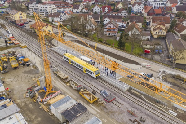 Aerial view of a yellow train on a construction site, crane and workers during construction, the Hermann Hesse Railway, Althengstett, Black Forest, Germany