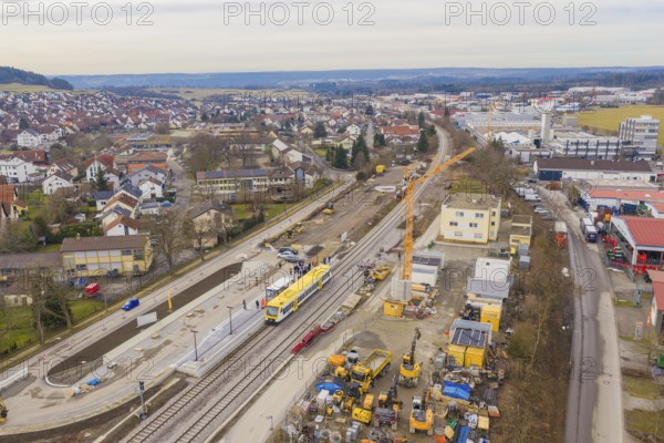 City view with train station and construction sites, surrounded by houses and a yellow train, acceptance of the Hermann Hesse Railway, Calw, Black Forest, Germany