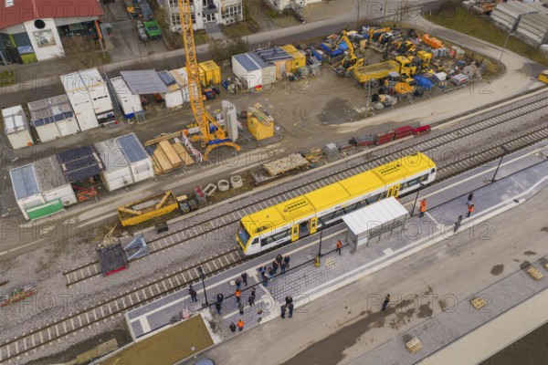Station scene with yellow train and construction work, workers and cranes against an urban backdrop, acceptance of the Hermann Hesse Railway, Althengstett, Black Forest, Germany