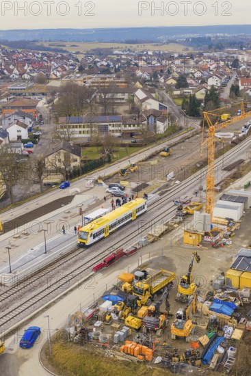 Station under construction with yellow train, construction cranes and houses in the background, bustling atmosphere, acceptance of the Hermann Hesse Railway, Althengstett, Black Forest, Germany