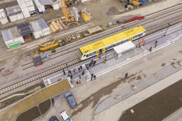 Bird's eye view of a train station with a yellow train and working people, bus ride taken by the Hermann Hesse Railway, Calw, Black Forest, Germany