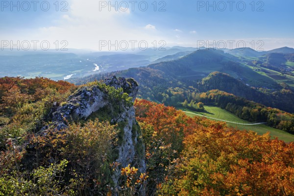View from the Gisliflue of an autumn-colored forest, behind the Jurassic foothills with water fluh and stripes in the light of the setting sun, Talheim, Canton, Aargau, Switzerland