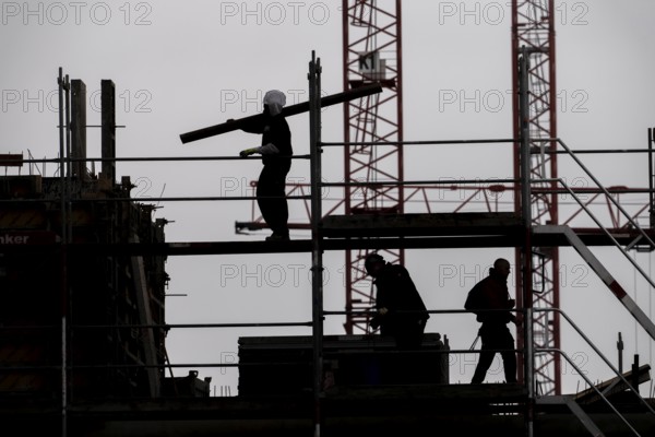 Construction site, scaffolding work on a large construction project, apartments and commercial premises, symbolic image of the construction industry