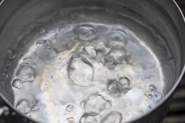 Water boils in a pot, boiling point, 100°C, air bubbles, symbolic picture