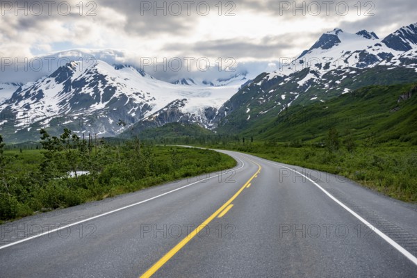 Road through mountain landscape, picturesque landscape with Worthington glacier, dramatic cloudy sky, Richardson Highway, Alaska, USA