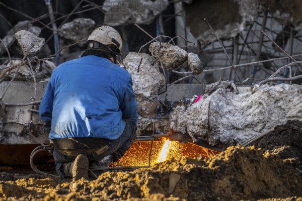 Workers with cutting torches demolishing the 120-meter long motorway bridge of the A516, across Teutoburger Straße in Oberhausen-Sterkrade, the bridge, built in 1970 was severely damaged, traffic continues to roll on the remaining west bridge, after demolition, the eastern part is rebuilt using a process that is unique in the world to date, 40 meter long precast concrete beams are assembled one after the other, reducing construction time from 24 to 7 months, After the completion of this bridge, the western part will also be rebuilt, North Rhine-Westphalia, germany