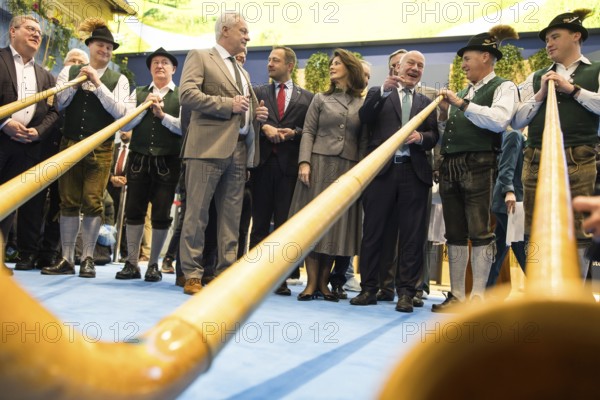 Joachim Rukwied (President of the German Farmers' Association), Alios Rainer (Federal Minister for Agriculture, Food and Home Affairs), Christophe Hansen (Commissioner for Agriculture and Rural Development), Michaela Kaniber (Minister of State for Food, Agriculture, Forestry and Tourism in Bavaria) and Kai Wegner (Governing Mayor of Berlin) between alphorn players at the Bavarian stand during the opening tour of the Green Week at the exhibition grounds in Berlin on 16 January 2026. The trade fair for the agricultural and food industry will take place from 16 to 25 January 2026